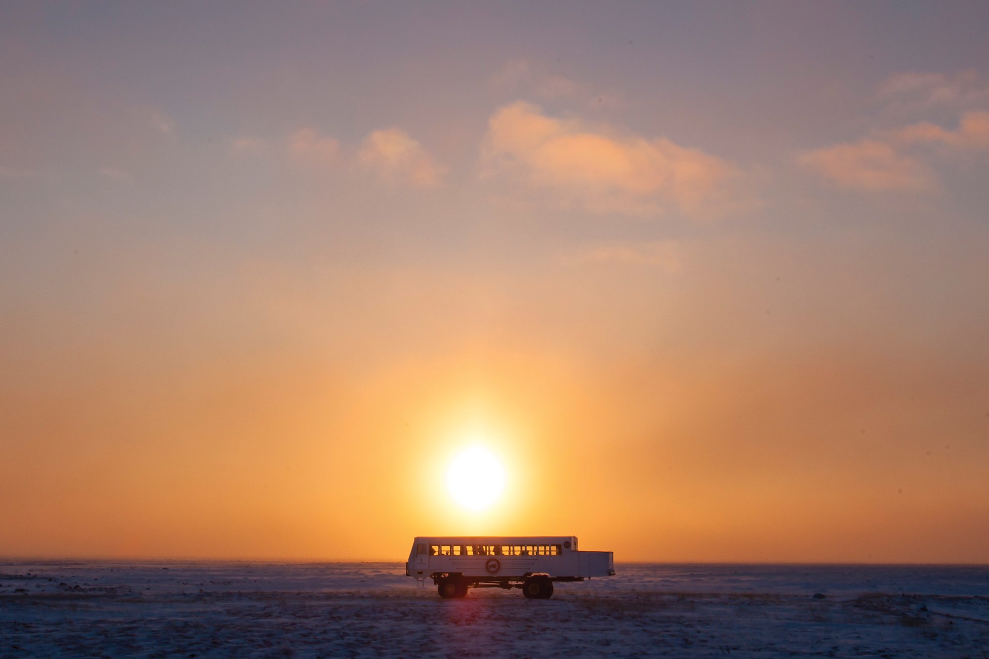A Tundra Buggy driving into the sunset in Churchill, Canada