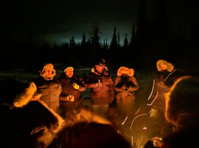 Group of people around the fire on the tundra at Dan's Diner in Churchill, Canada.