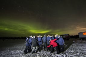 A group of new friends beneath the northern lights in Churchill, Manitoba, Canada.