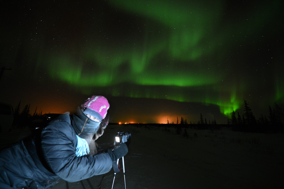 A guest prepares their camera to capture a photo of the aurora.