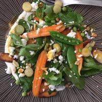 A beautifully plated salad of carrots, feta cheese, split peas, and more.