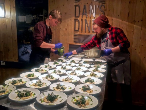 Chef Jared Fosser and sous chef finish plating dishes for guests.