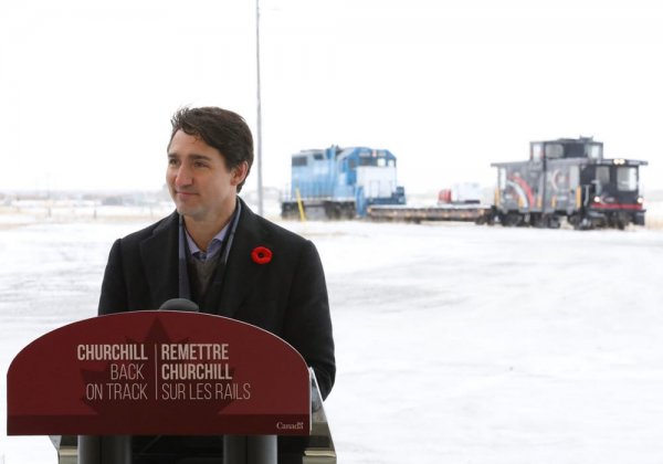 Justin Trudeau speaks to Churchillians standing behind a podium that has a sign that reads "Churchill, Back on Track"